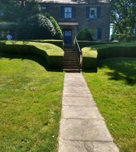 A stone walkway leading to a house with stairs