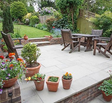 A patio with a table and chairs and potted plants