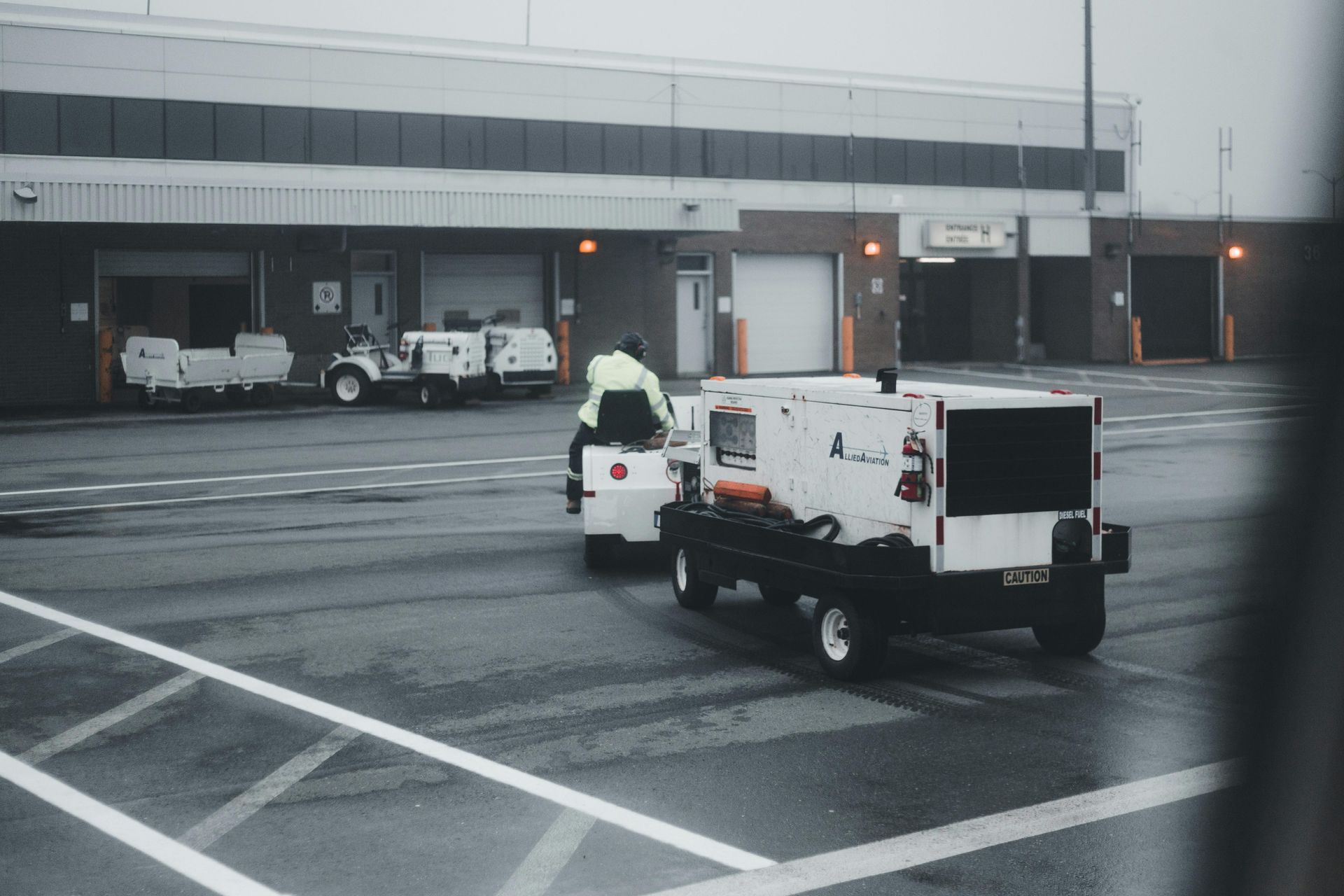 A couple of vehicles are parked in a parking lot in front of a building.
