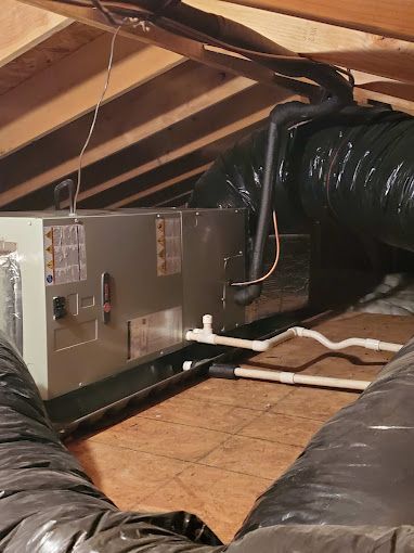An air conditioner is installed in the attic of a house.