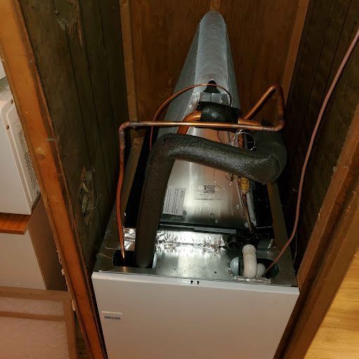 A gas heater is sitting inside of a wooden cabinet.