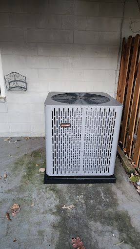 A large air conditioner is sitting in a garage next to a brick wall.