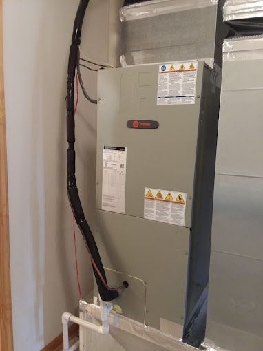 An air conditioner is sitting in a room next to a wall.