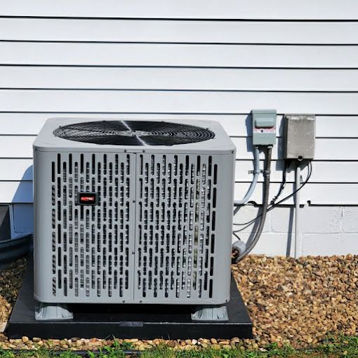 A large air conditioner is sitting outside of a house.