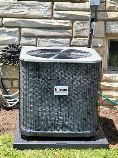 An air conditioner is sitting outside of a brick building.
