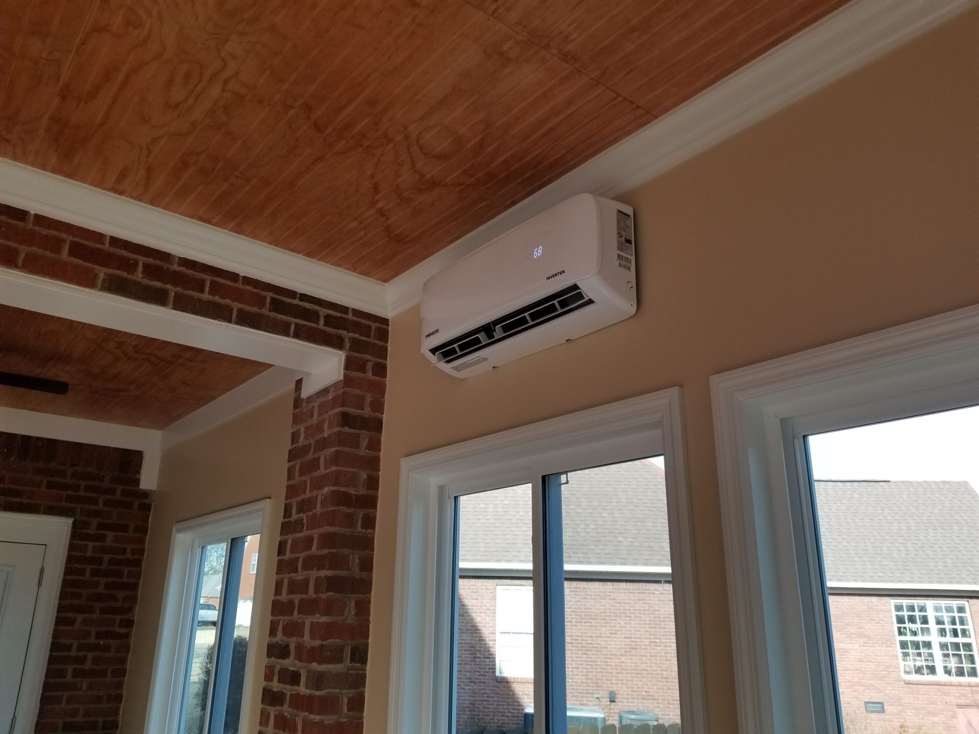 A person is installing shingles on a roof with a hammer.