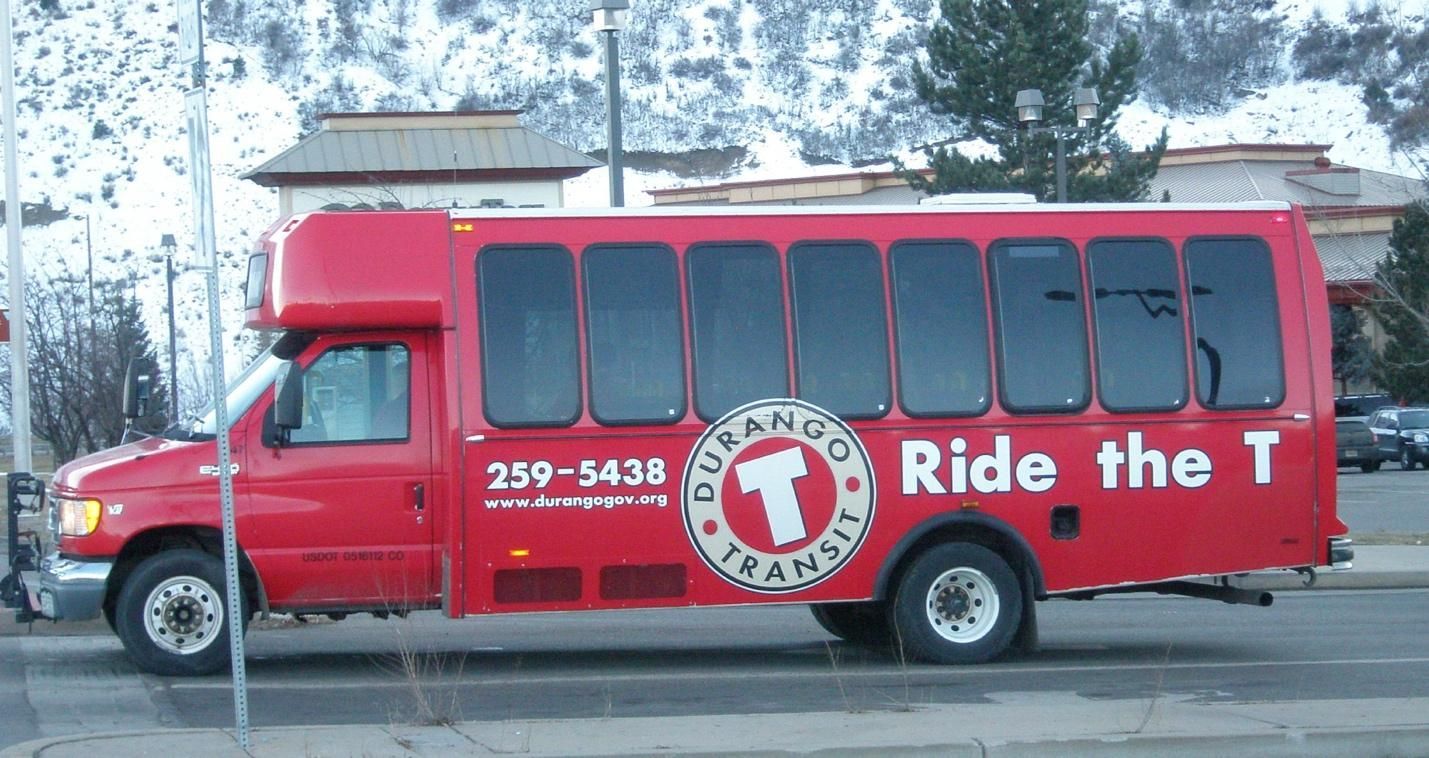 A red bus that says ride the t on the side.