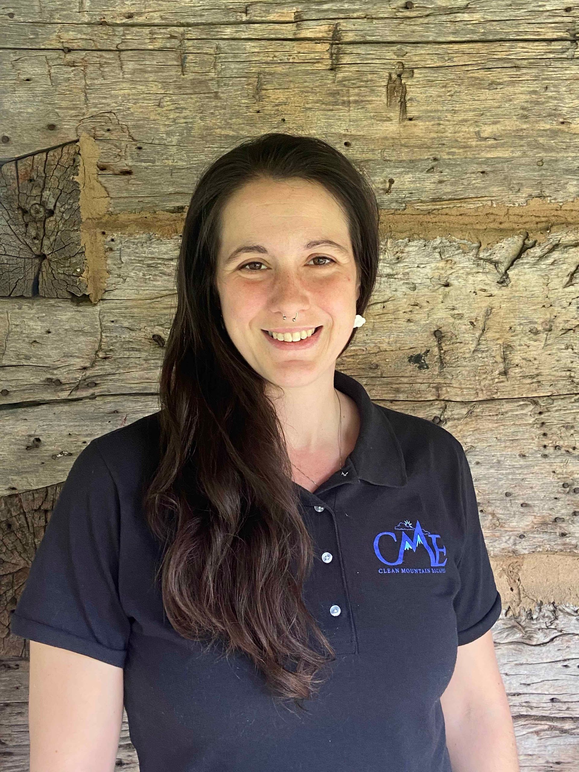 Owner of Boone NC House cleaning company is smiling in front of a wooden wall.