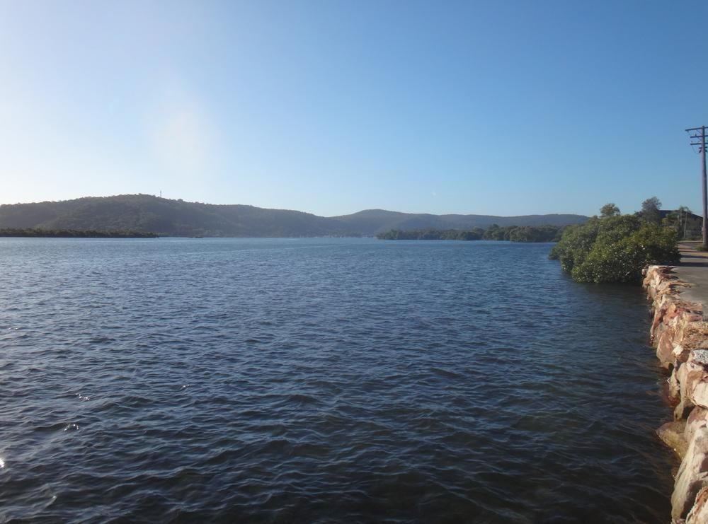 A Large Body Of Water With Mountains In The Background — Economy Waste Group | Skip Bins Central Coast In Davistown, NSW