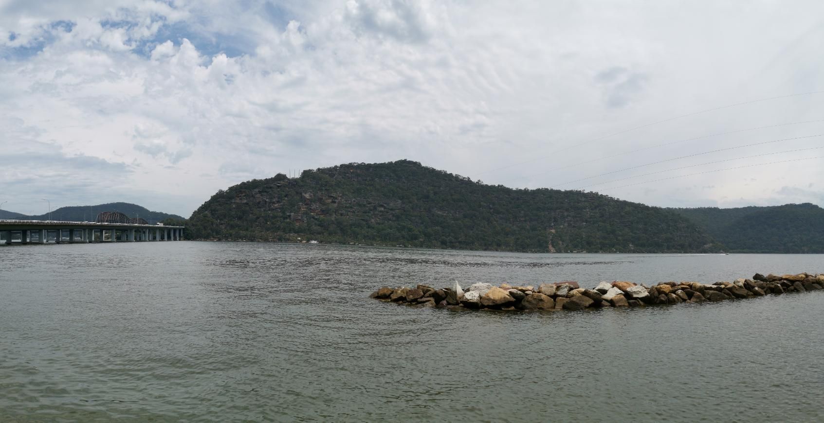 A Large Body Of Water With Mountains In The Background And A Bridge In The Distance — Economy Waste Group | Skip Bins Central Coast In Mooney Mooney, NSW