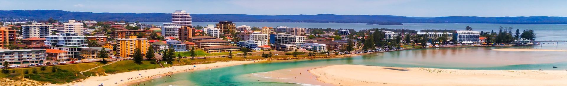 A Blurry Picture Of A Beach With A City In The Background — Economy Waste Group | Skip Bins Central Coast In Gosford, NSW