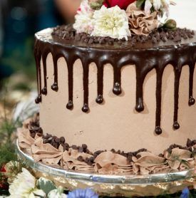 A chocolate cake with flowers on top is sitting on a table.