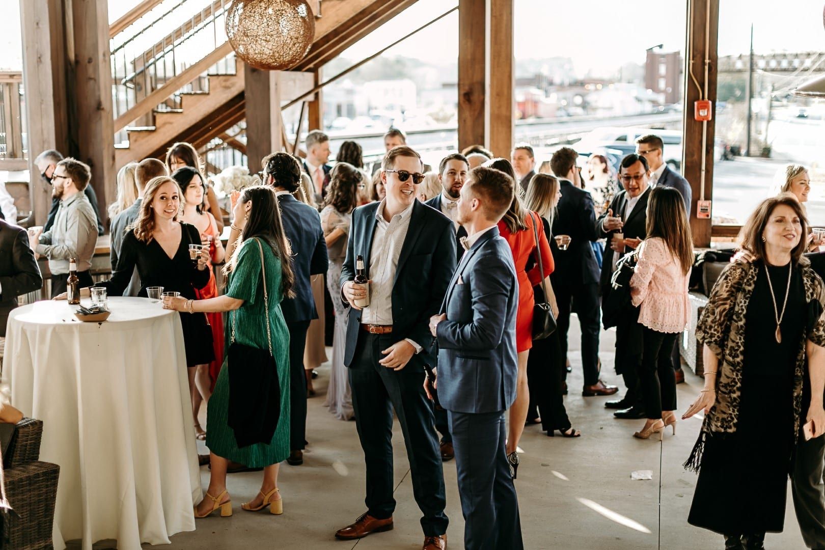 A large group of people are posing for a picture at a wedding reception.