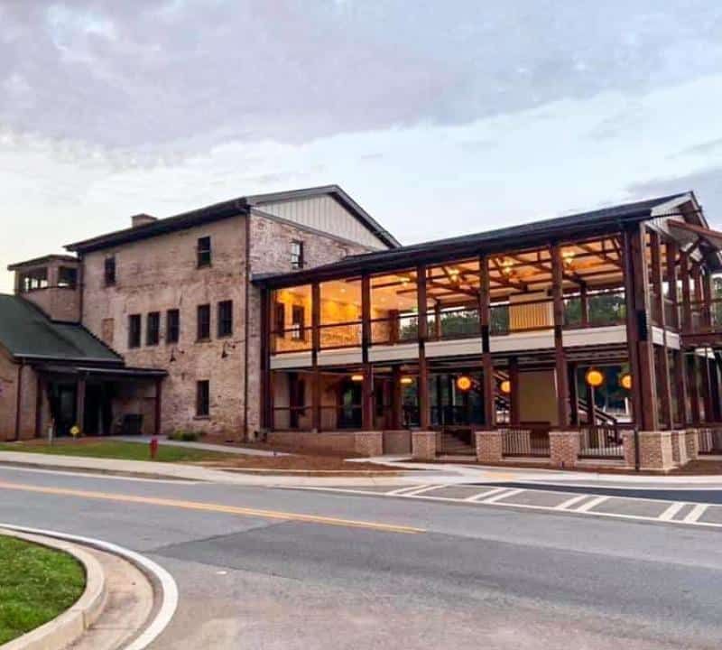 A large building with a lot of windows is on the side of the road