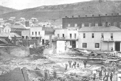 A black and white photo of a city with a building that says ' kitub ' on it