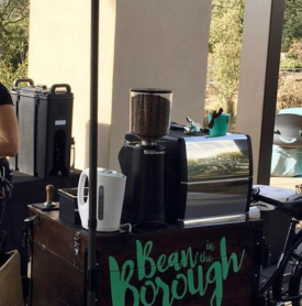 A woman stands behind a bean in the borough stand
