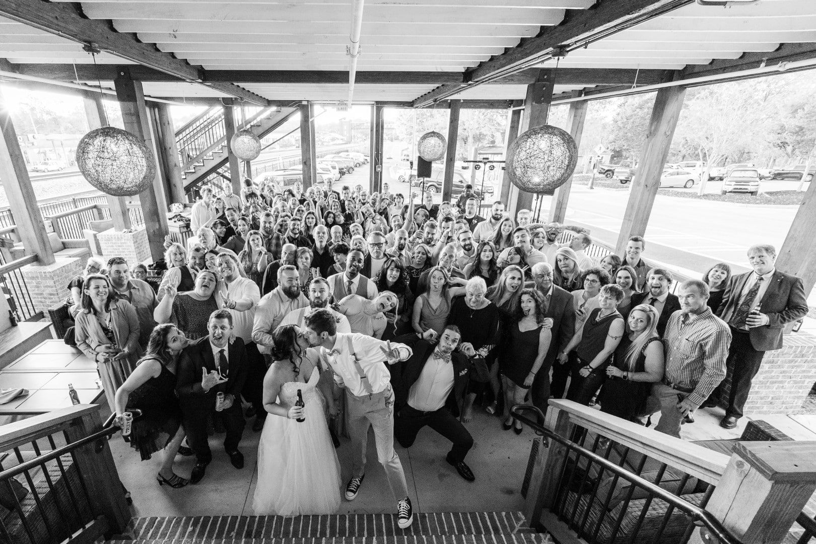 A large group of people are posing for a picture at a wedding reception.