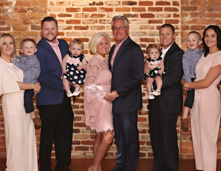 A family posing for a picture in front of a brick wall