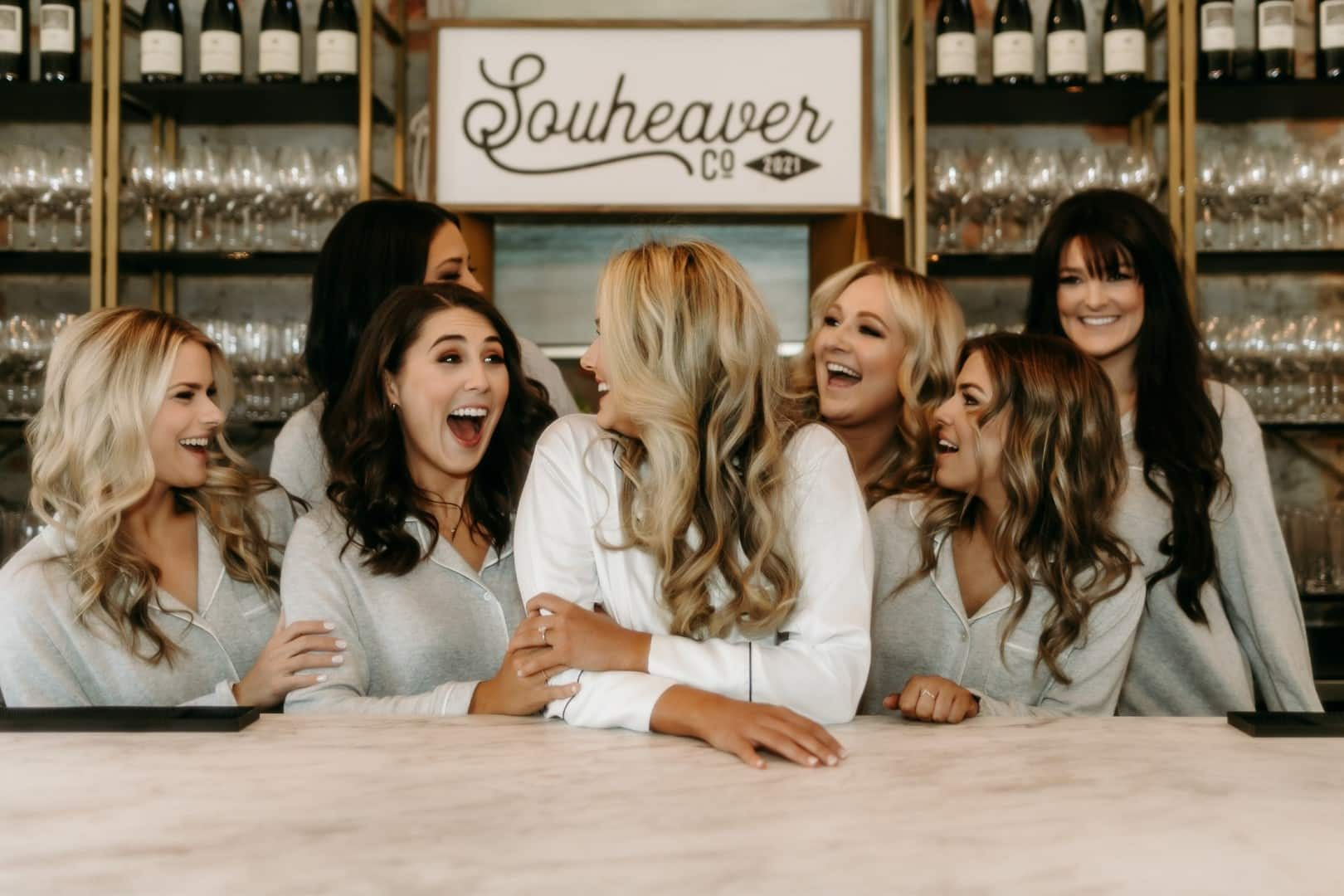 A group of women are sitting at a bar laughing.