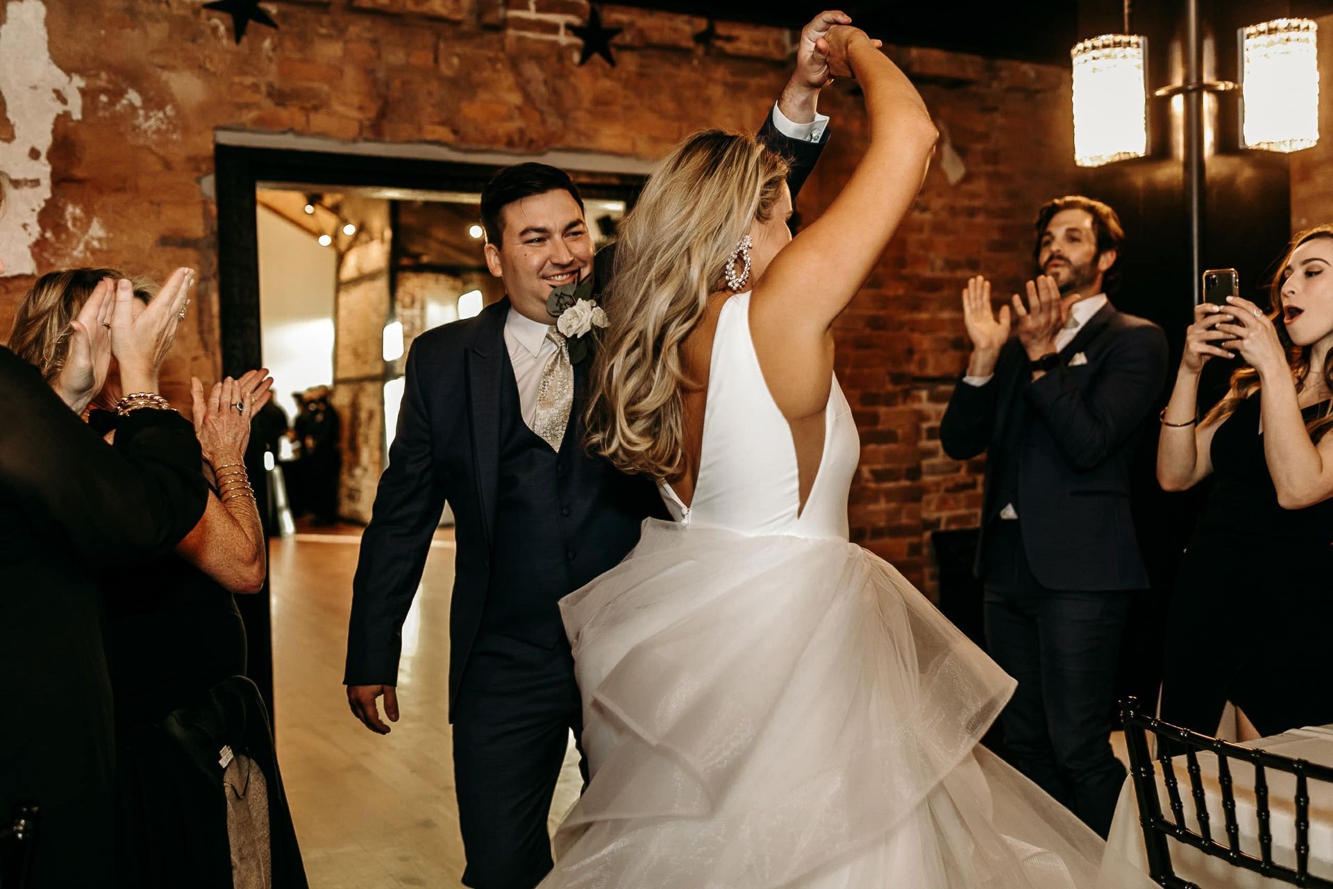 A bride and groom are dancing at their wedding reception.