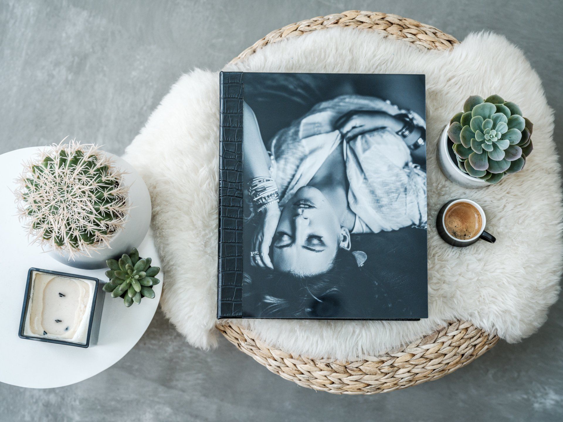 A book, plant, and cup of coffee on a table.