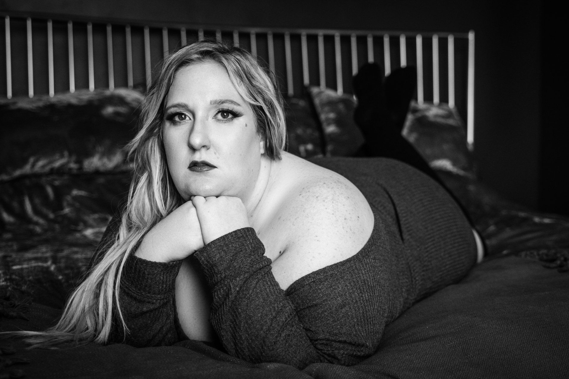 boudoir woman on bed with head resting on hands