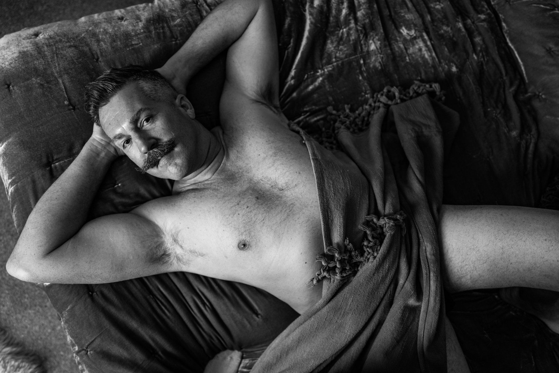man laying on bed with a blanket