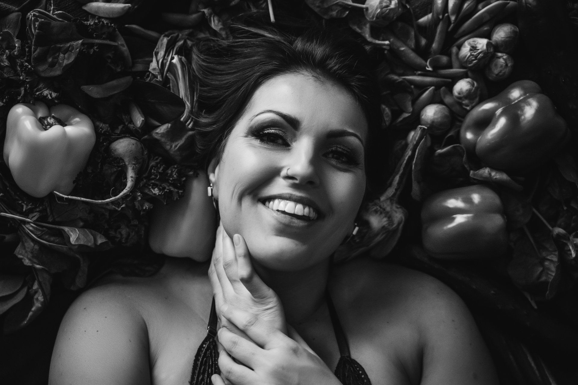 black and white image of woman surrounded by vegetables