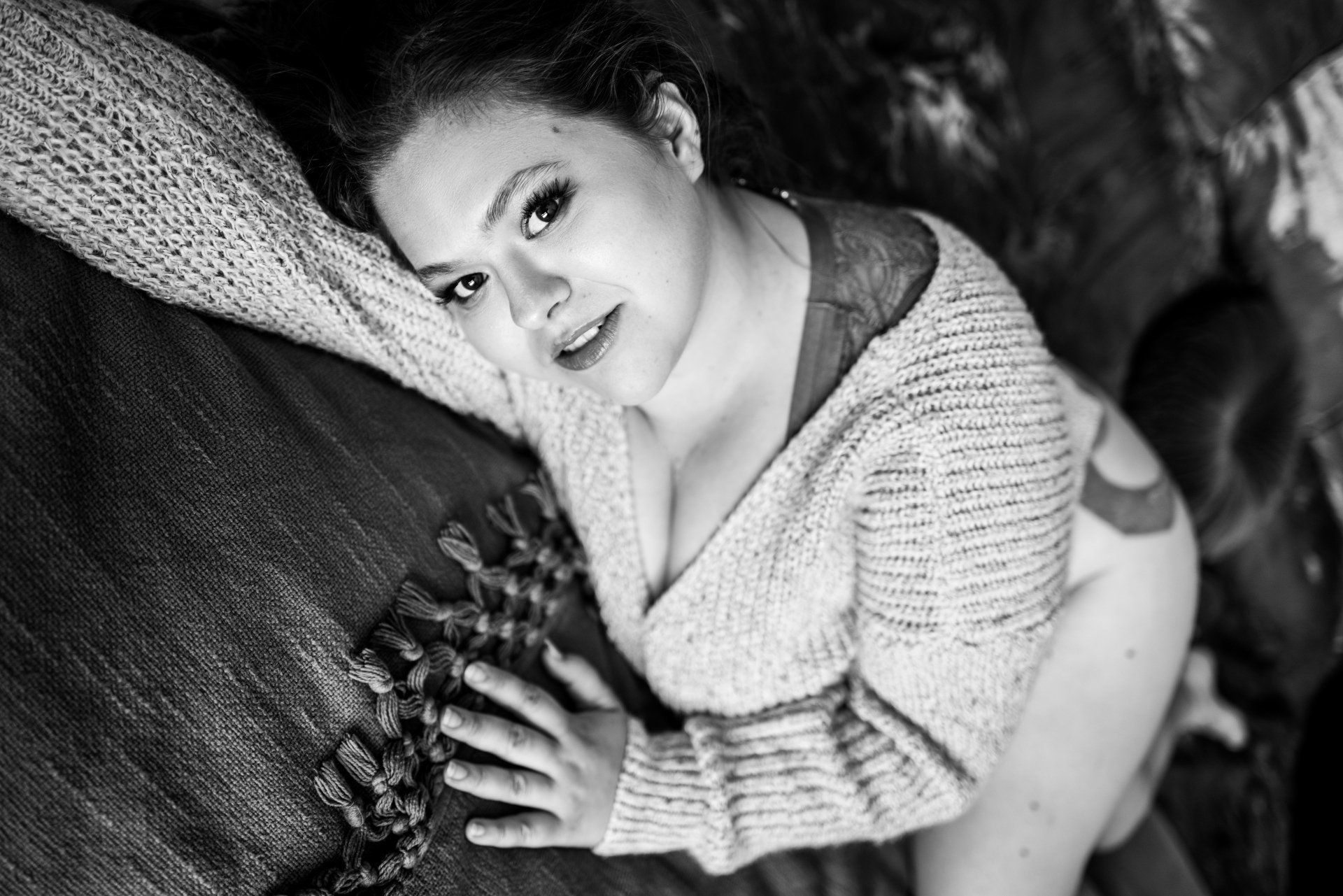 A woman posing on a bed for boudoir photography.