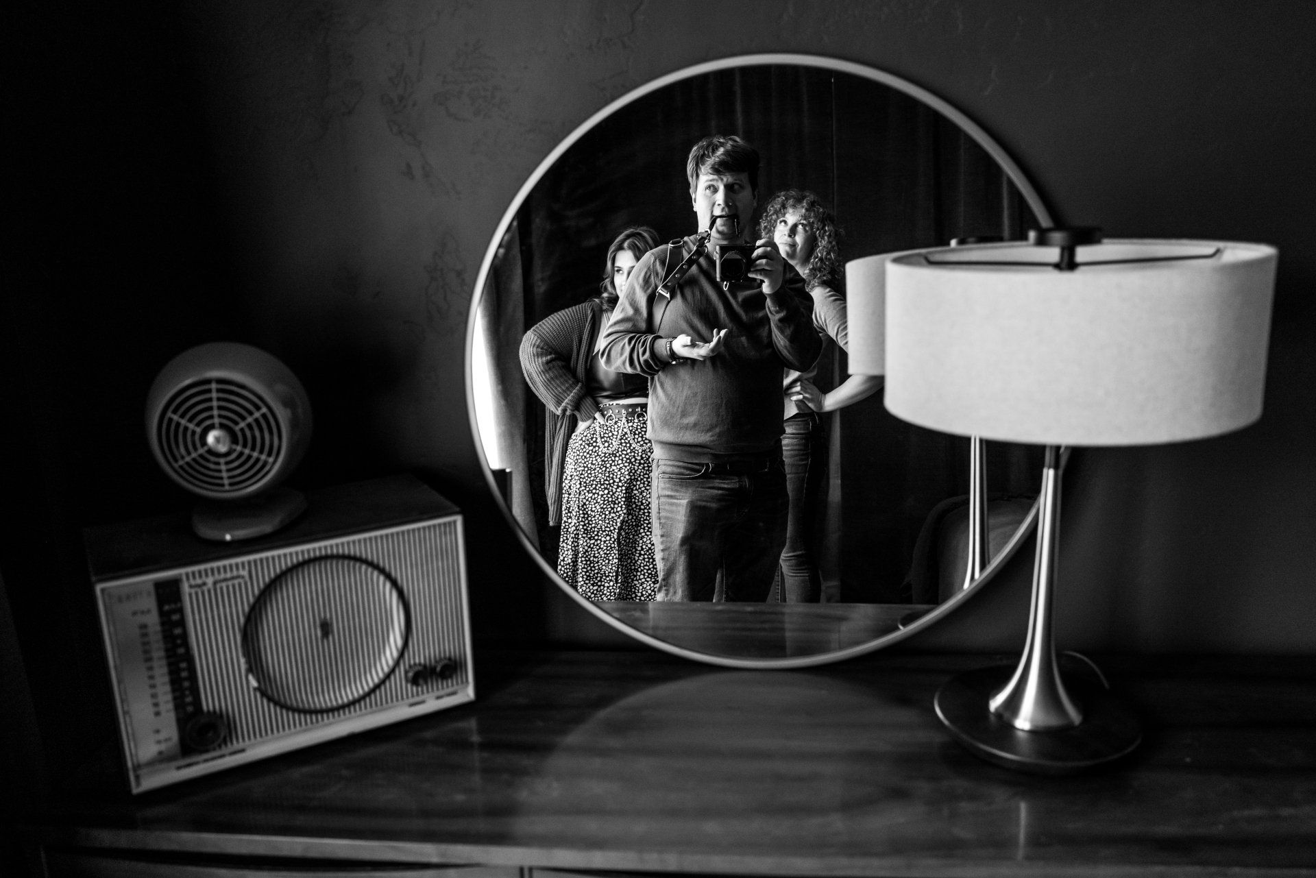 three people reflecting in the mirror