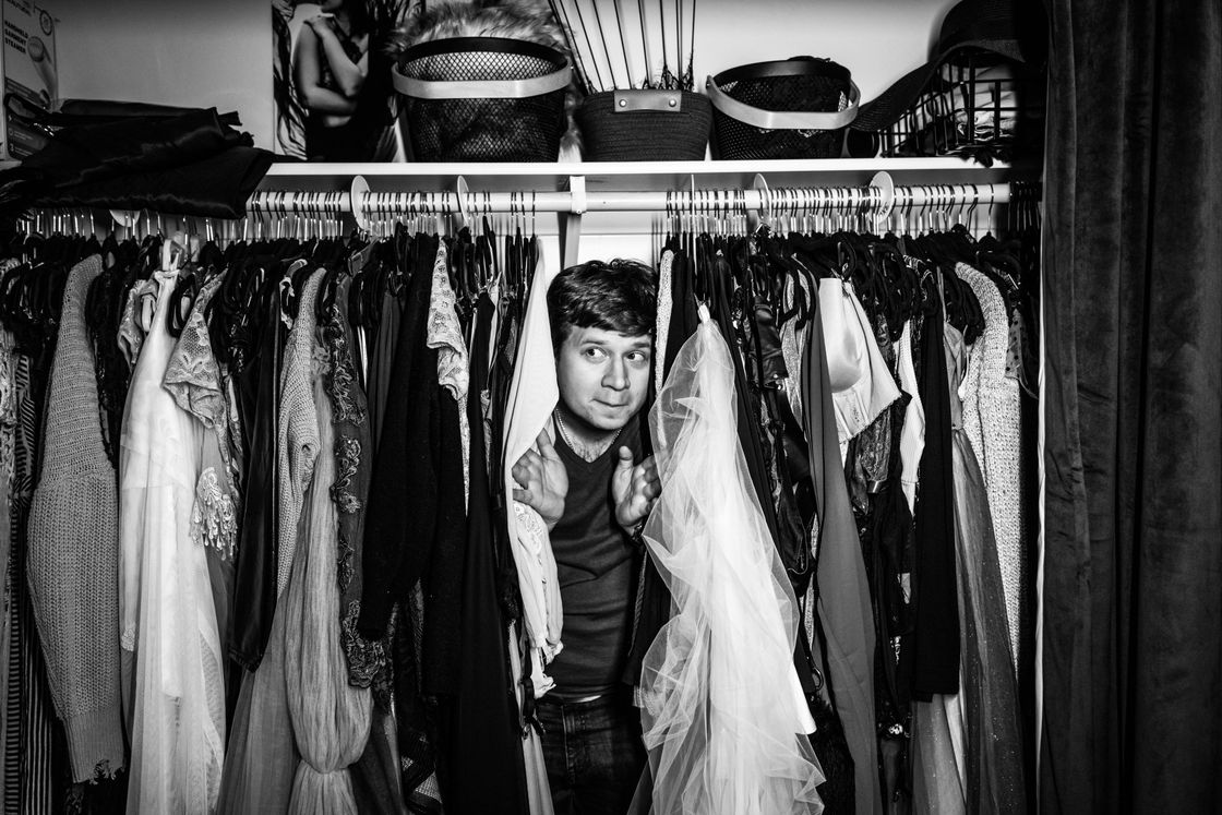 Mateusz hiding in a rack of clothes