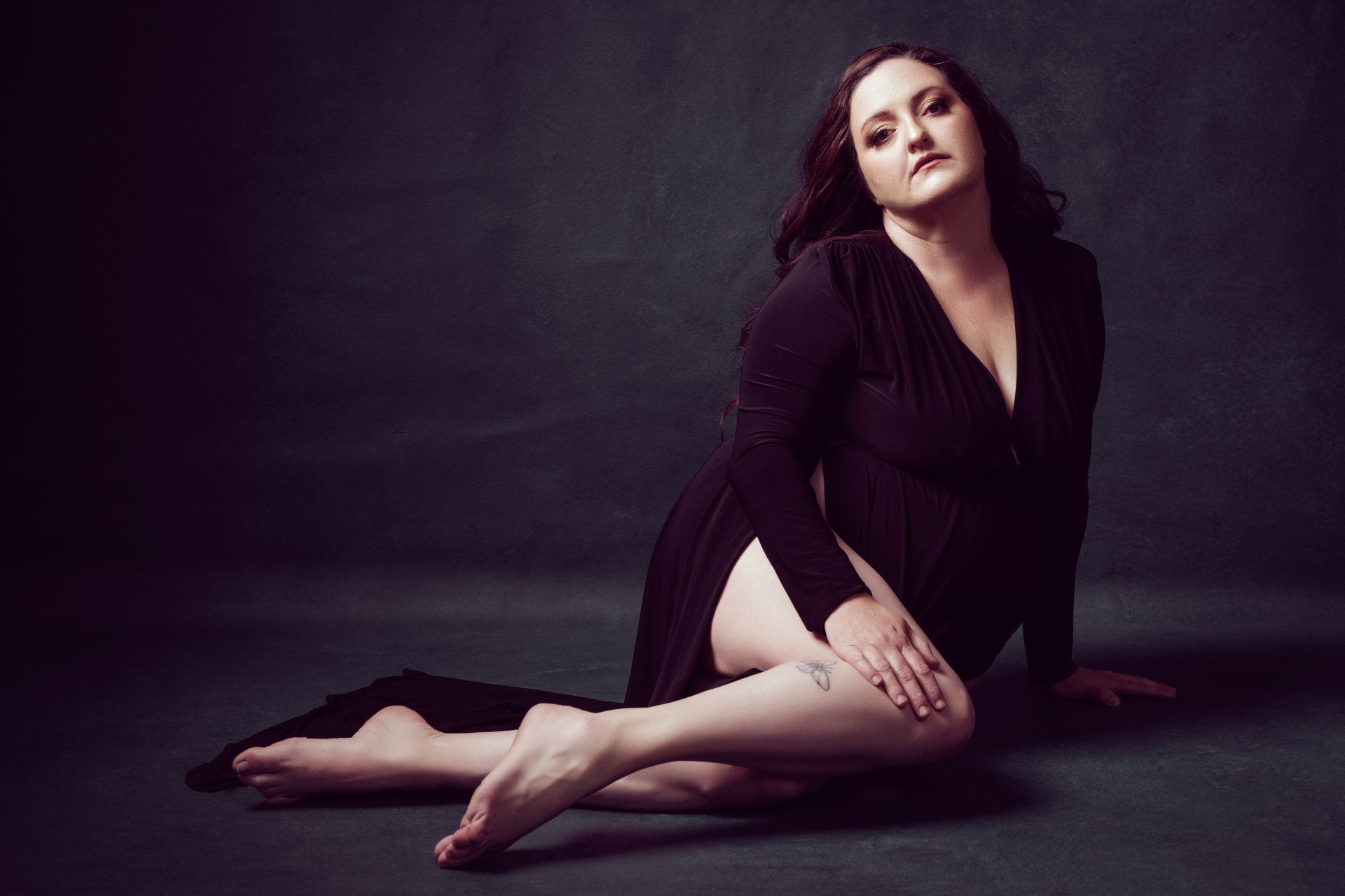 boudoir portrait of a woman sitting on floor in black dress