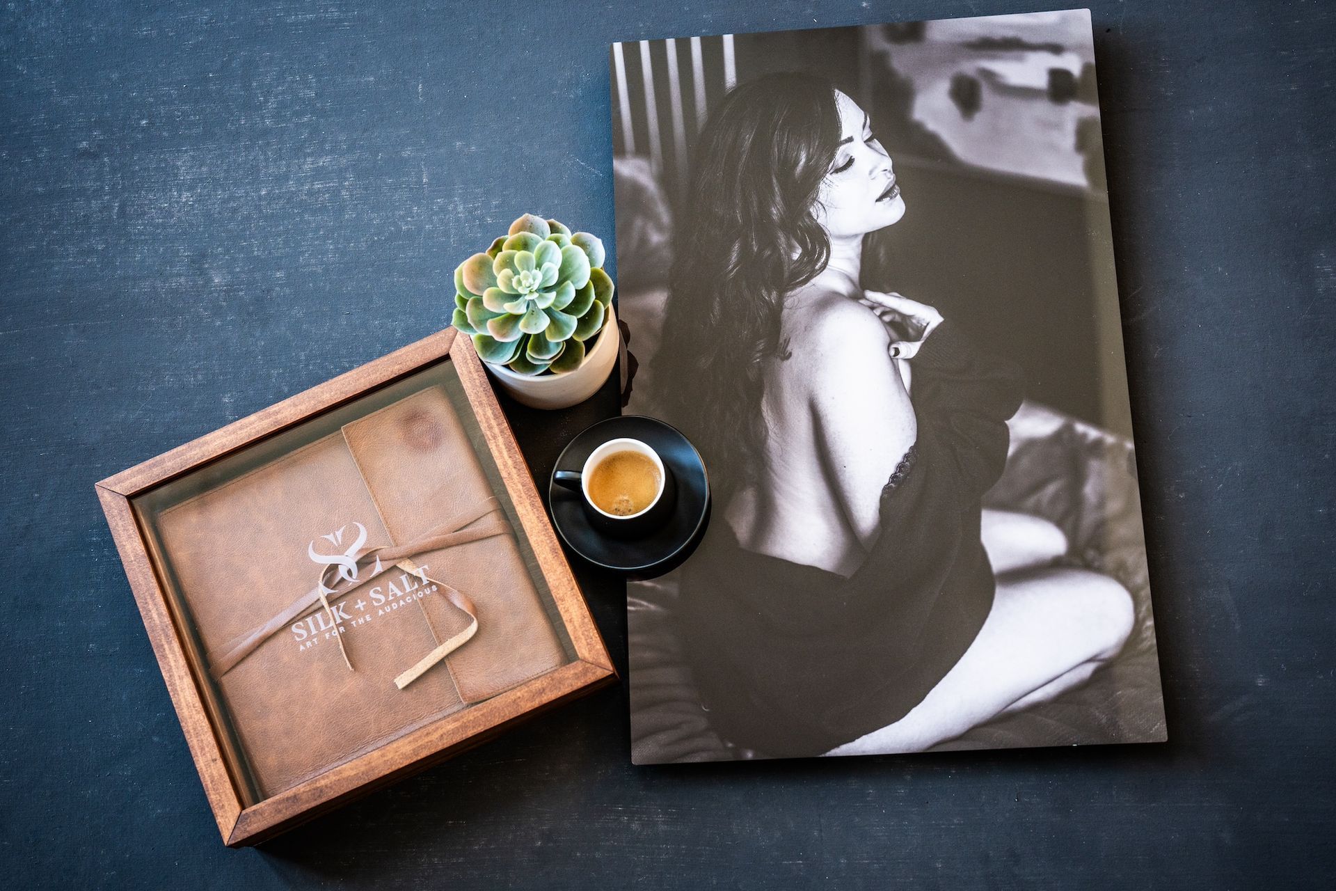 . A woman seated at a wooden table, enjoying a cup of coffee beside her in a cozy setting.