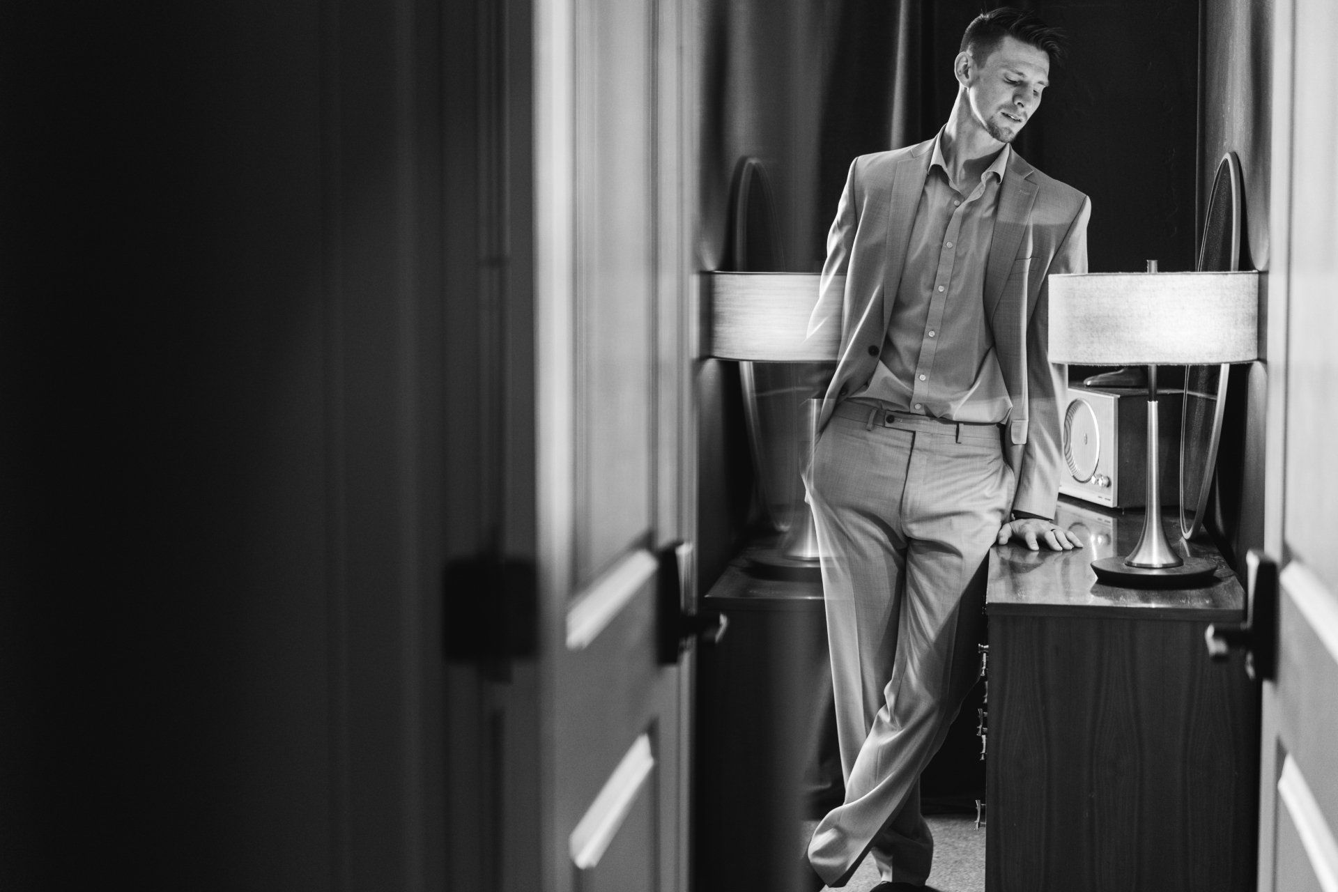 portrait of man in suit next to dresser