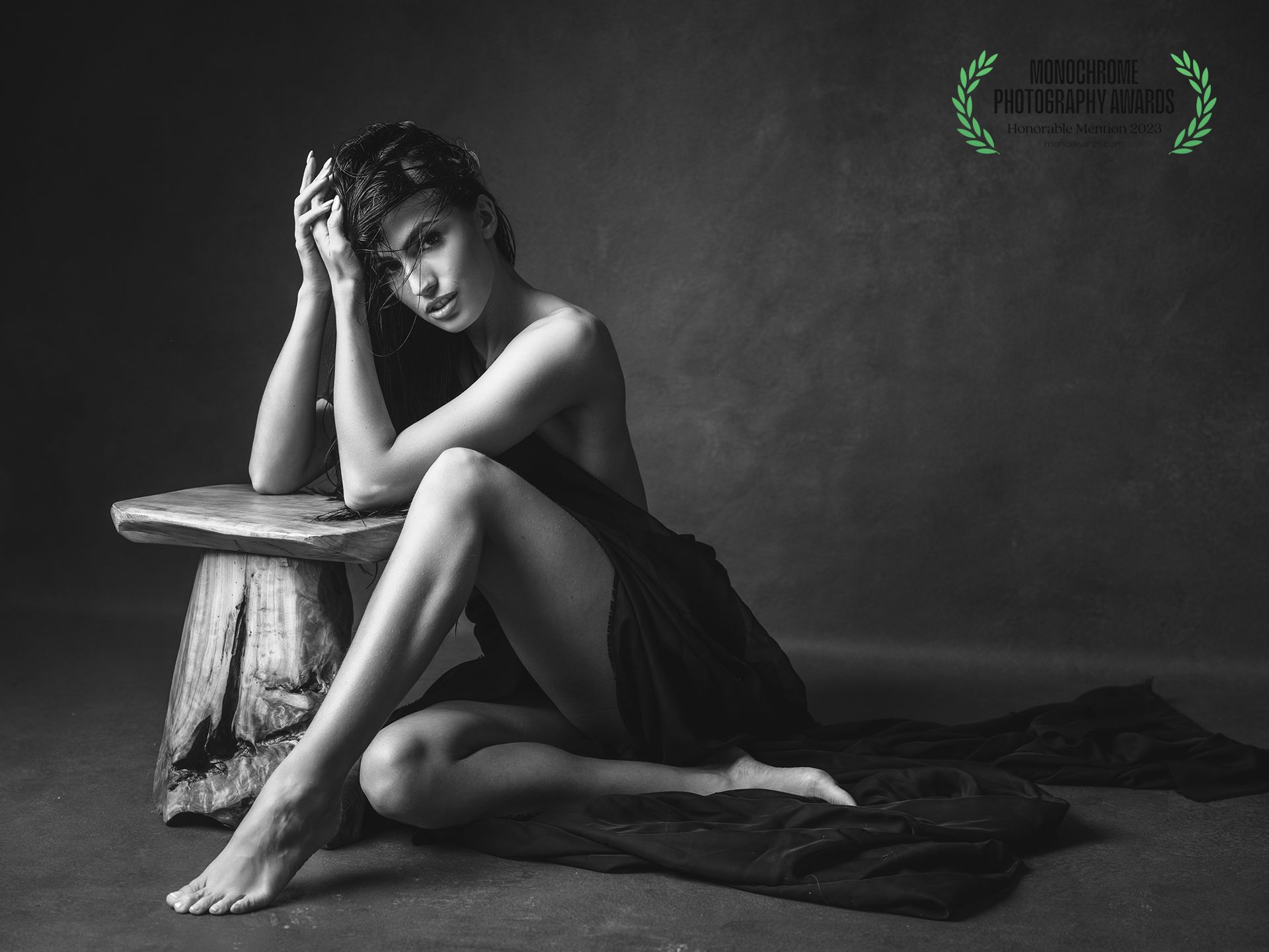young woman sitting on the floor with a small wooden stool