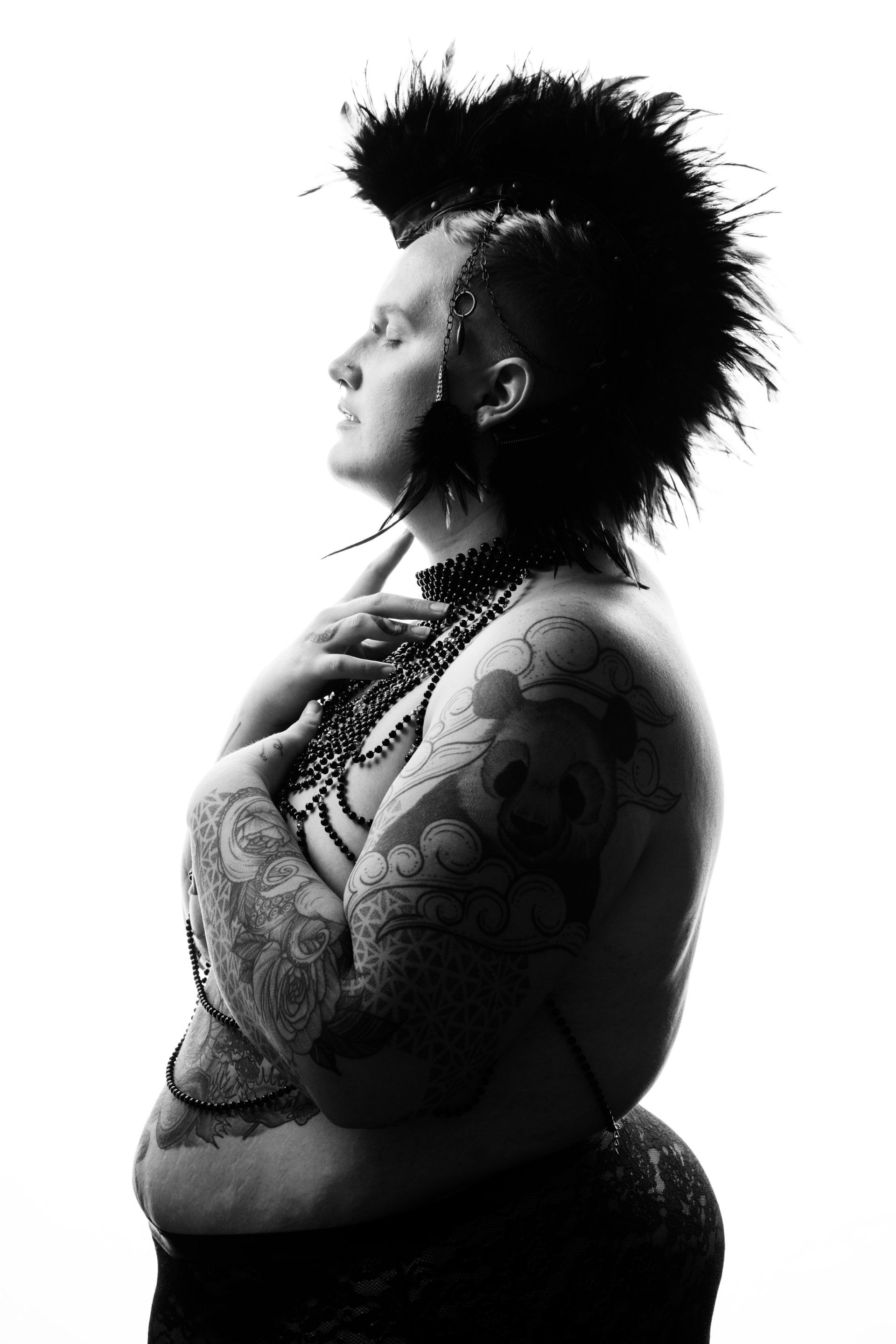 black and white portrait of a gender-fluid person wearing a feather headdress