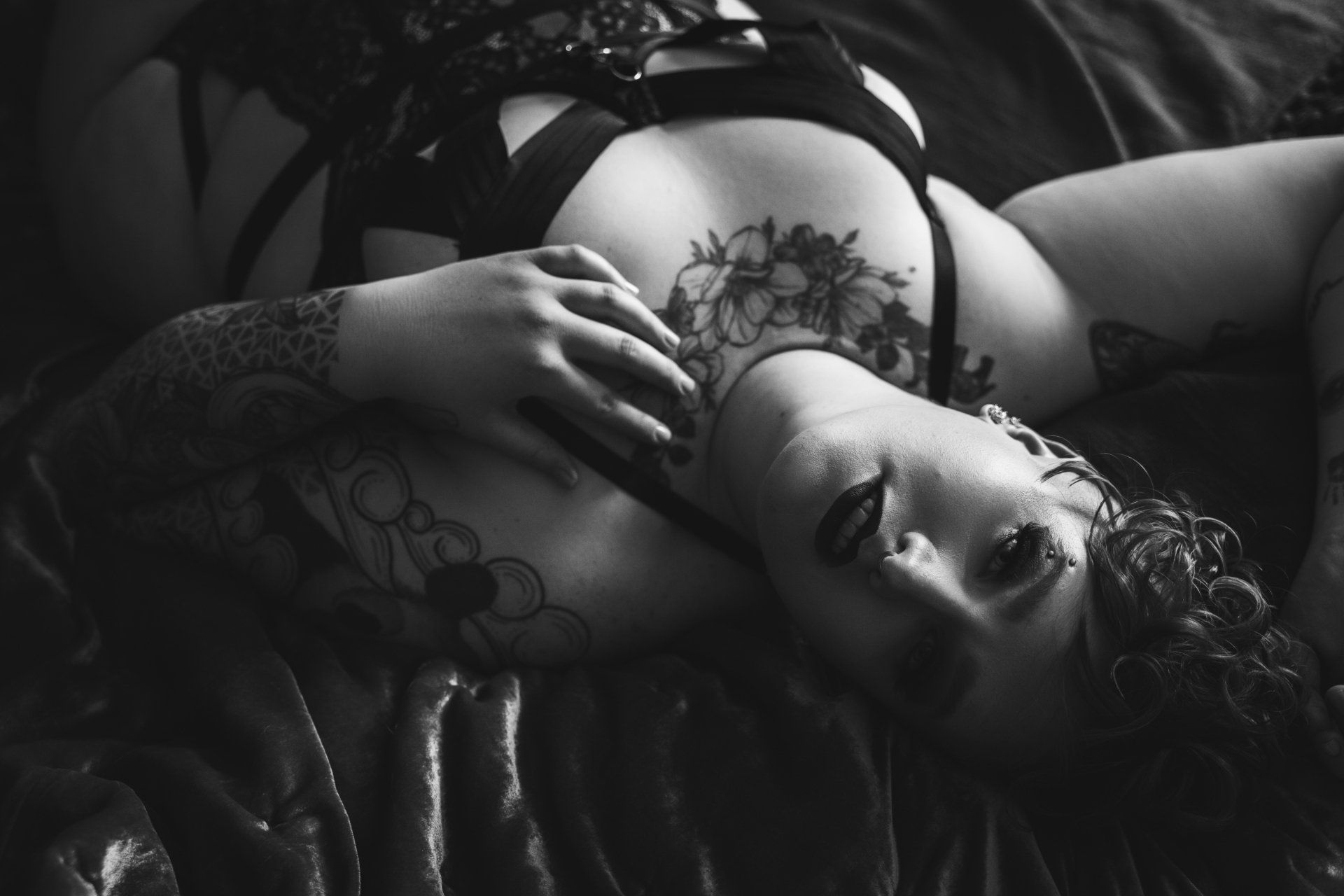 boudoir image of woman lying on back on bed