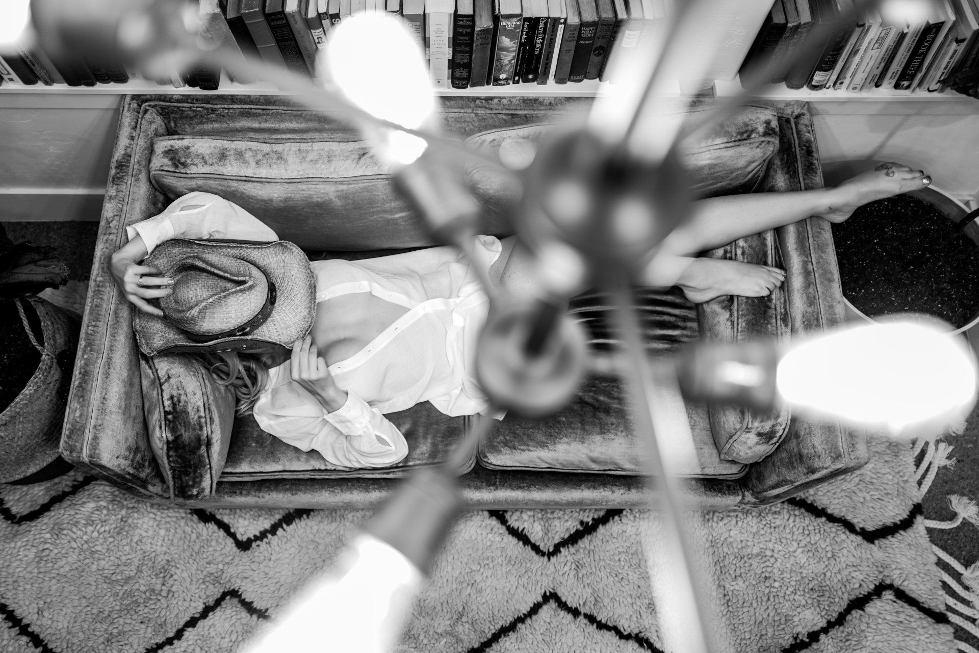 Lady lying on couch in a room filled with books.