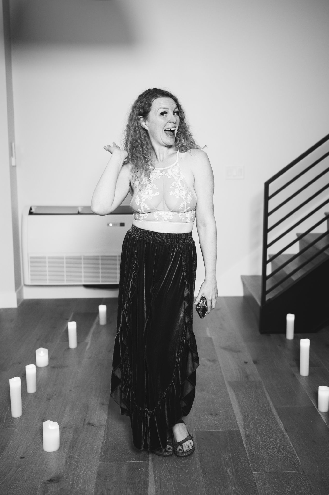 A woman dressed in a black skirt and top stands poised, exuding sophistication and grace.