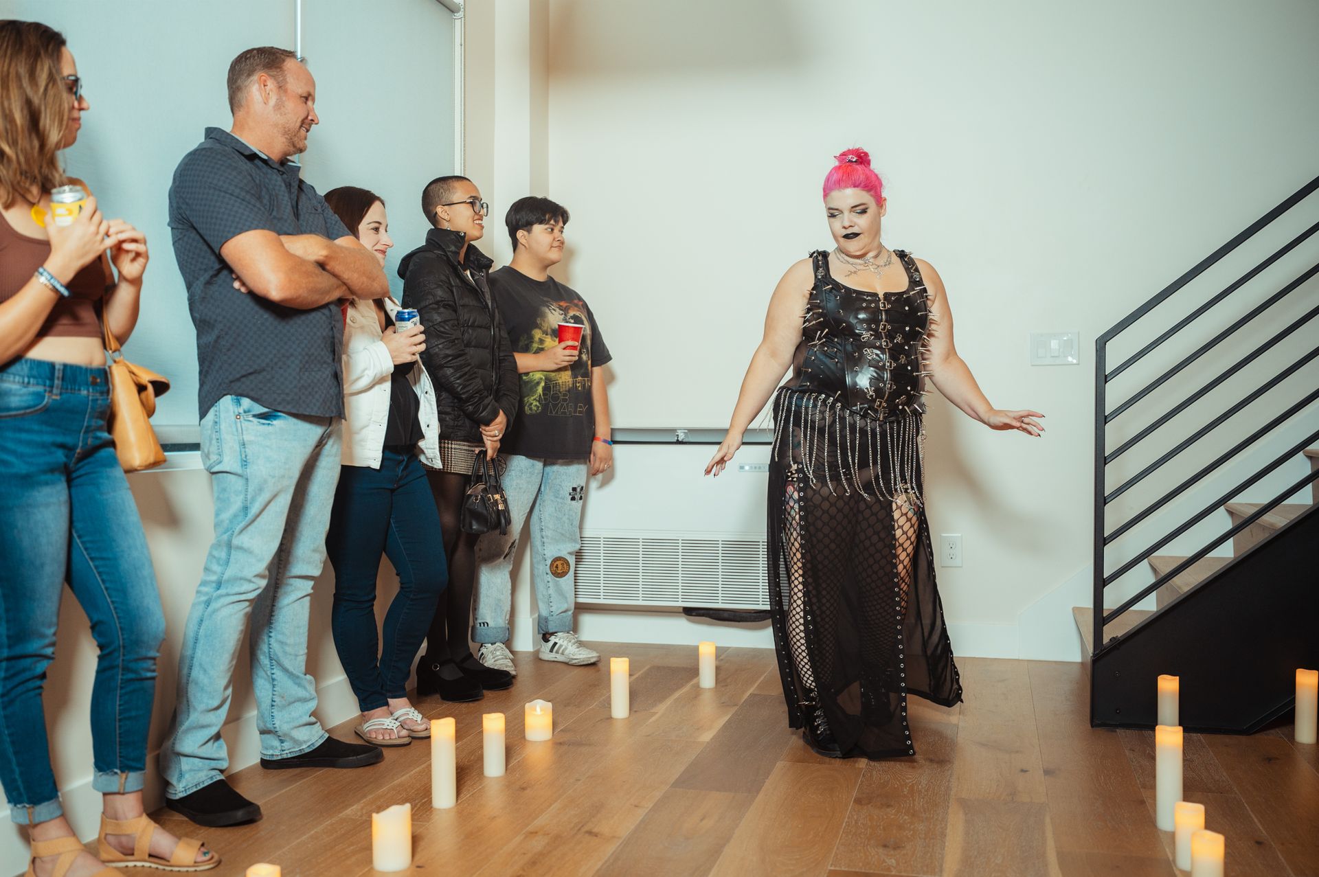 A woman in a dress stands confidently before an audience at the Silk + Salt Fashion Show, showcasing her style and poise.
