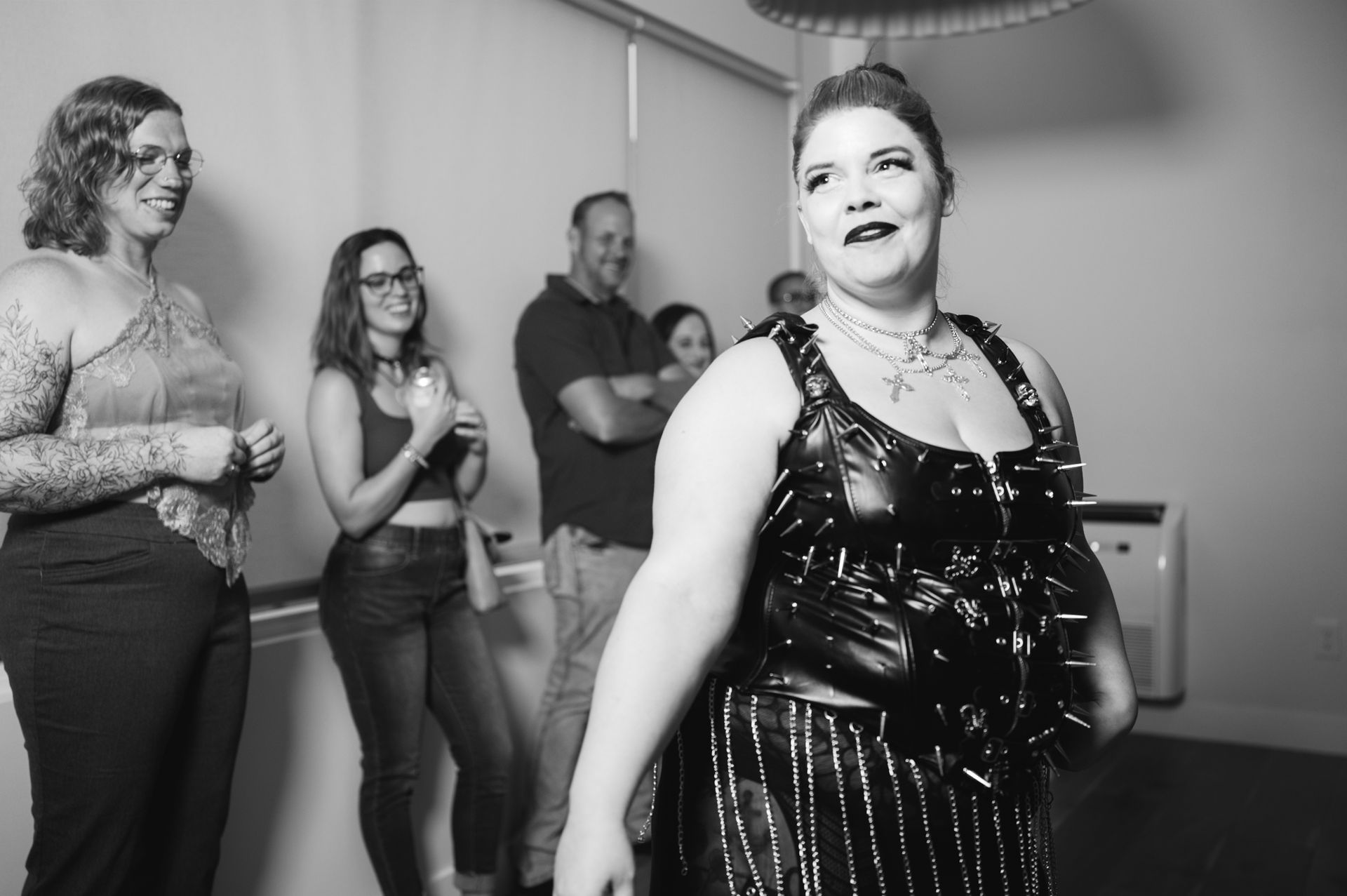 A woman in a dress dances with a group, embodying elegance and celebration in motion.