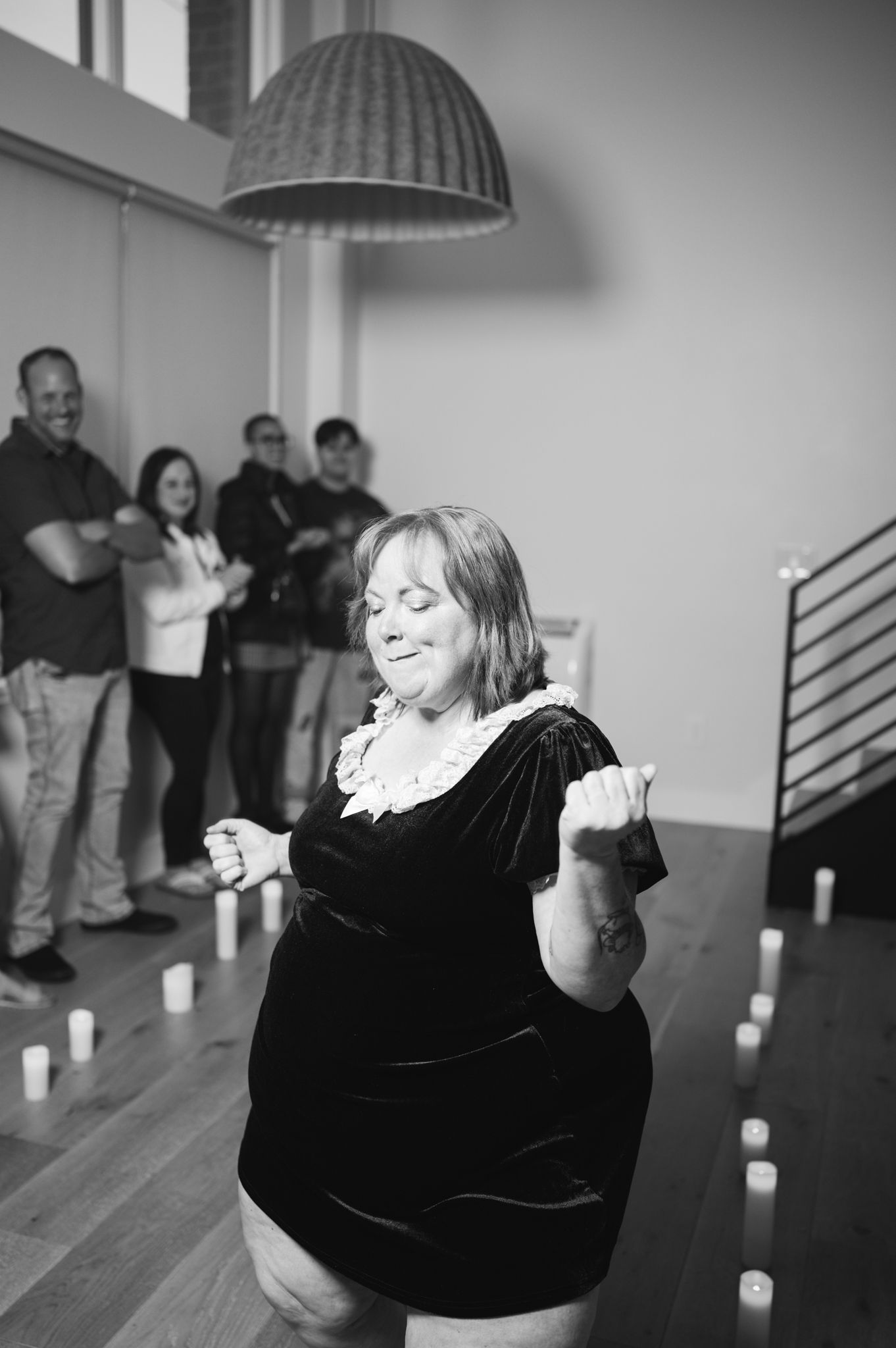 A women gracefully dance in a softly lit room adorned with flickering candles