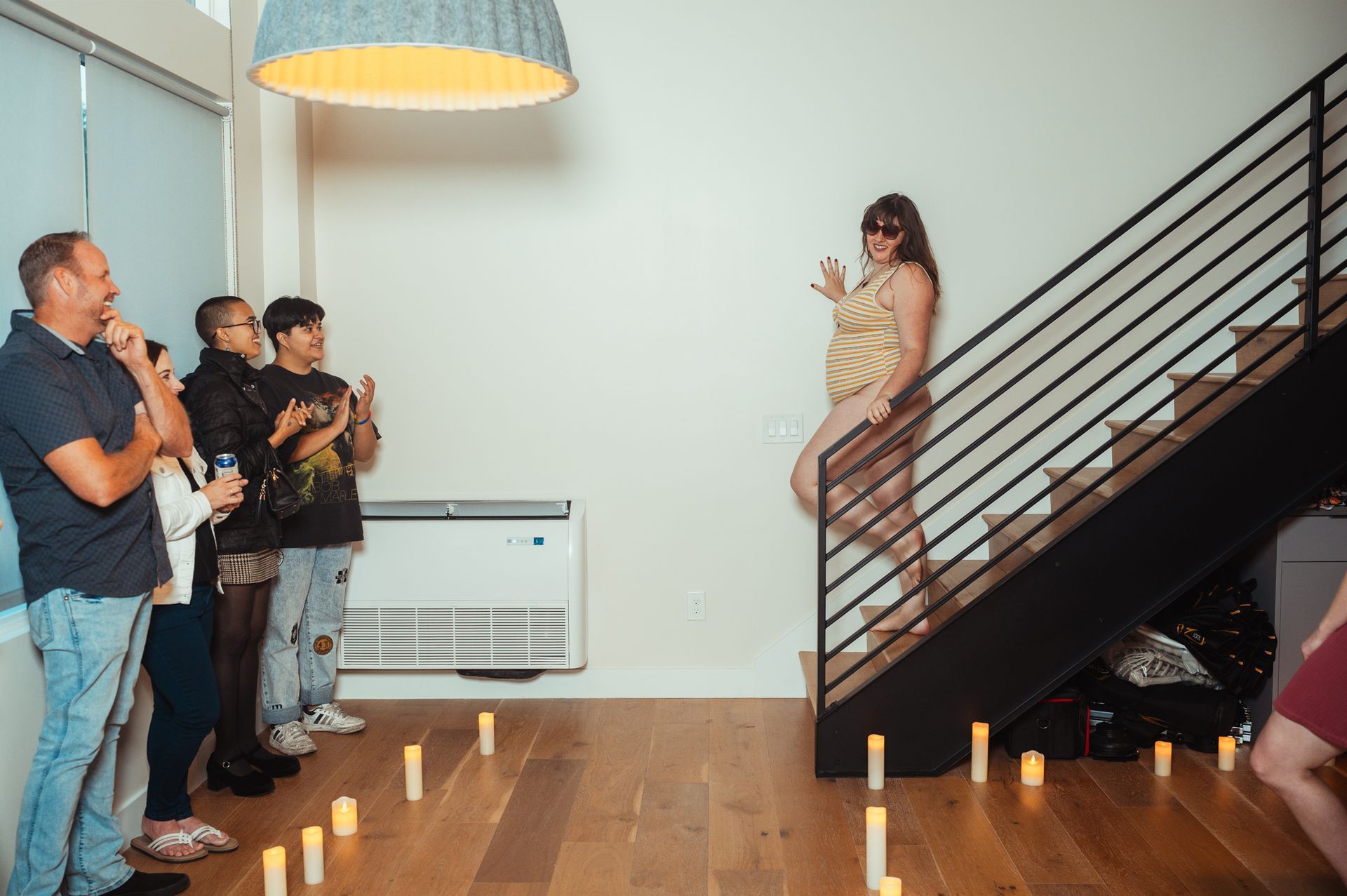 A woman is positioned on a stairway, surrounded by flickering candles that enhance the tranquil ambiance of the scene.