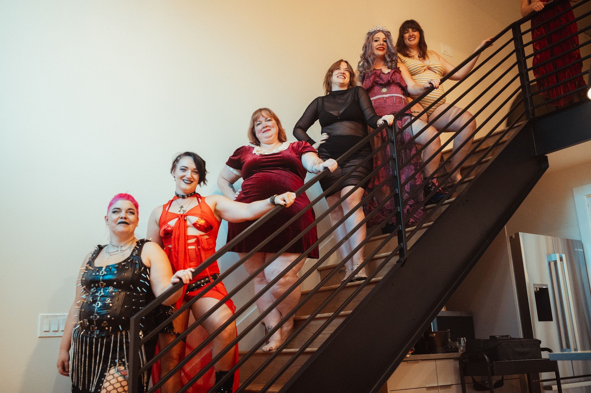 A group of women of various backgrounds posing on a staircase, exuding confidence and togetherness in their stance.