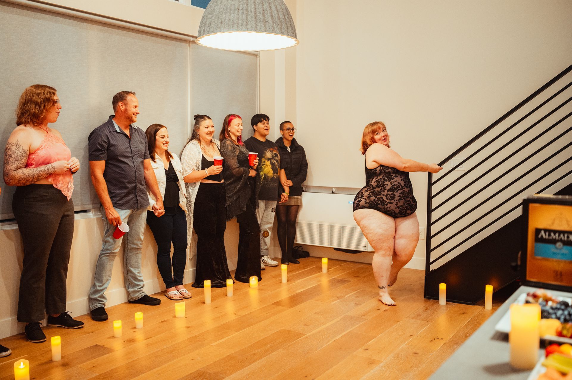 A woman in a black dress ascends a staircase, showcasing elegance and determination in her movement.