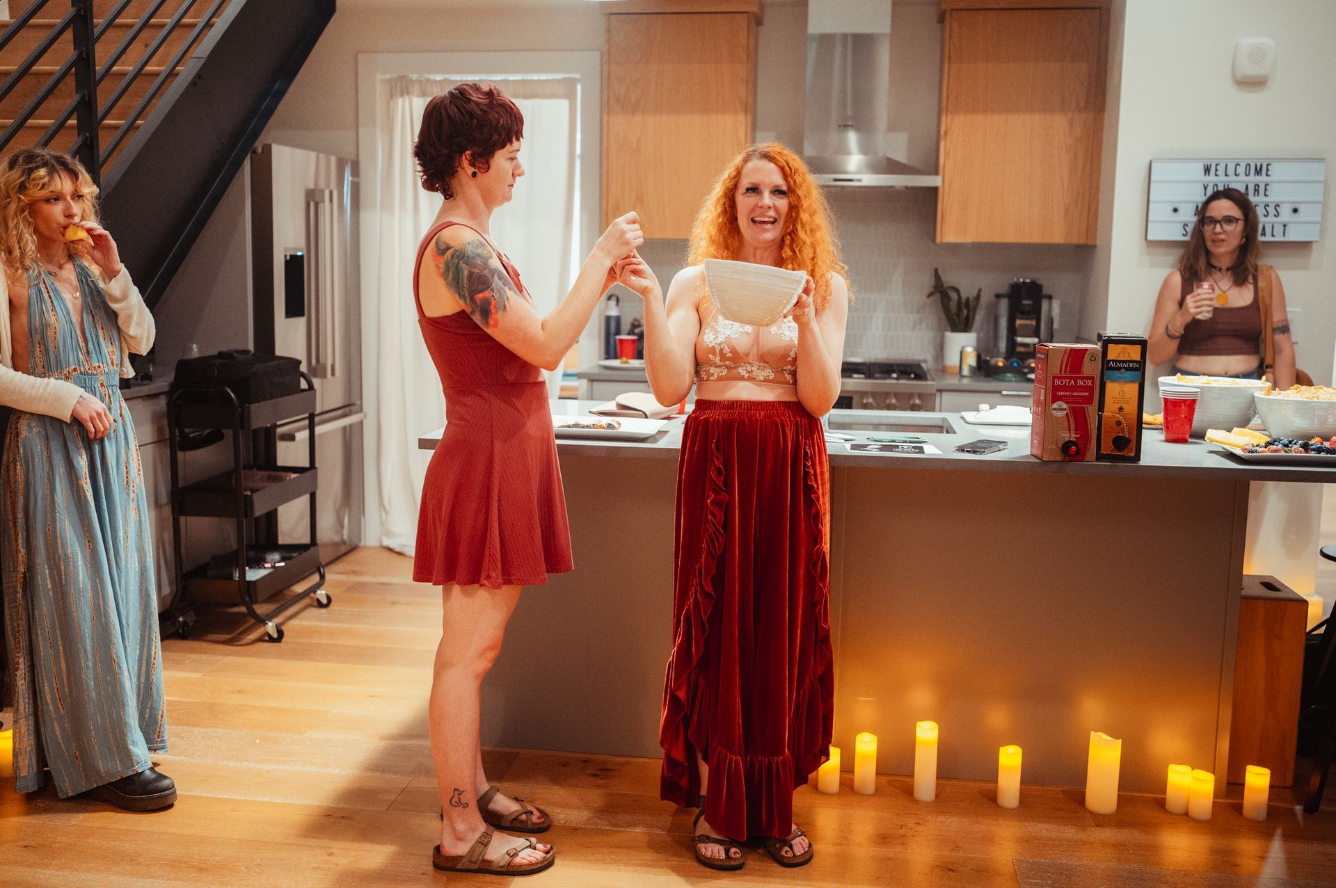 Two women in the kitchen with bowl on her hands.