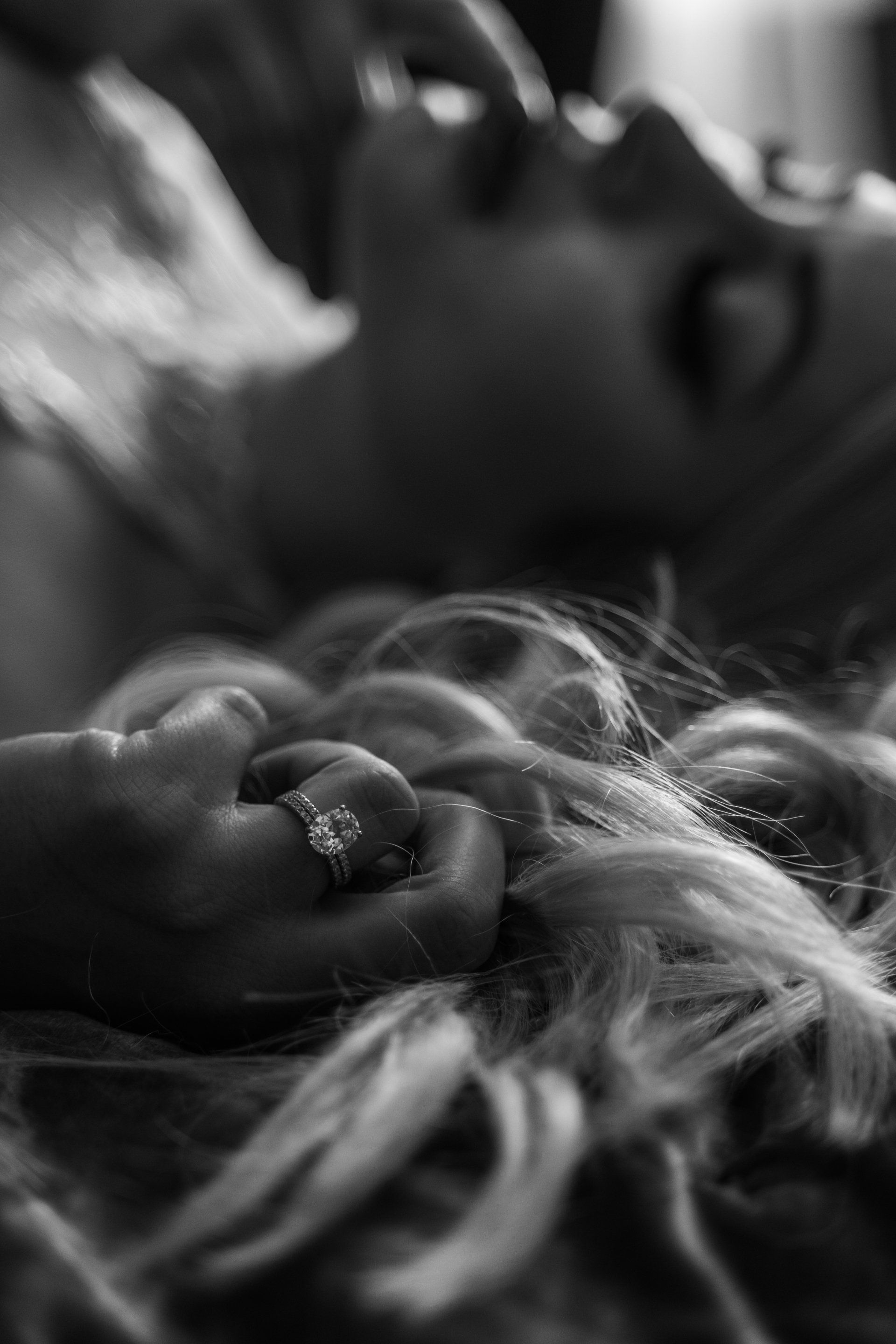 detail shot of engagement ring with hand in hair