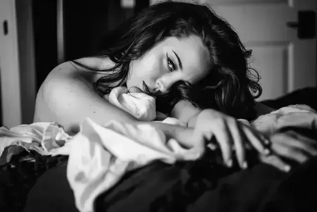 woman stretching her arms on the bed