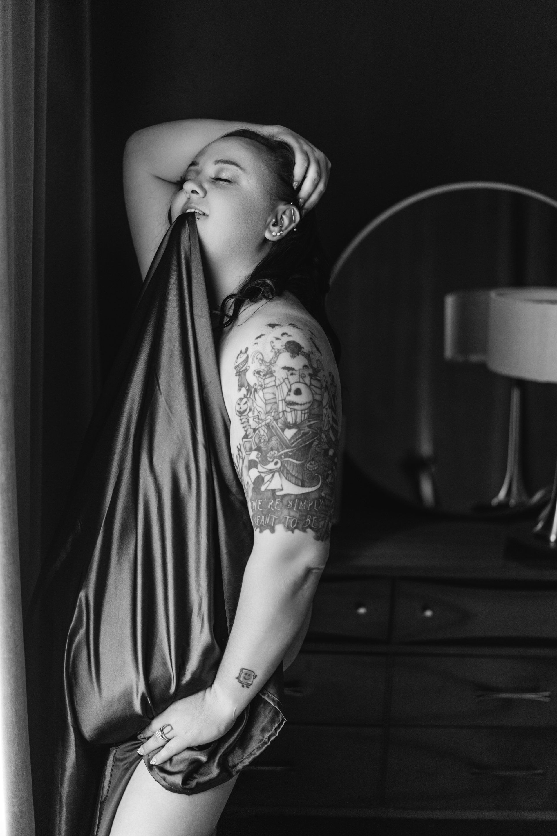 nude woman with sheet between teeth