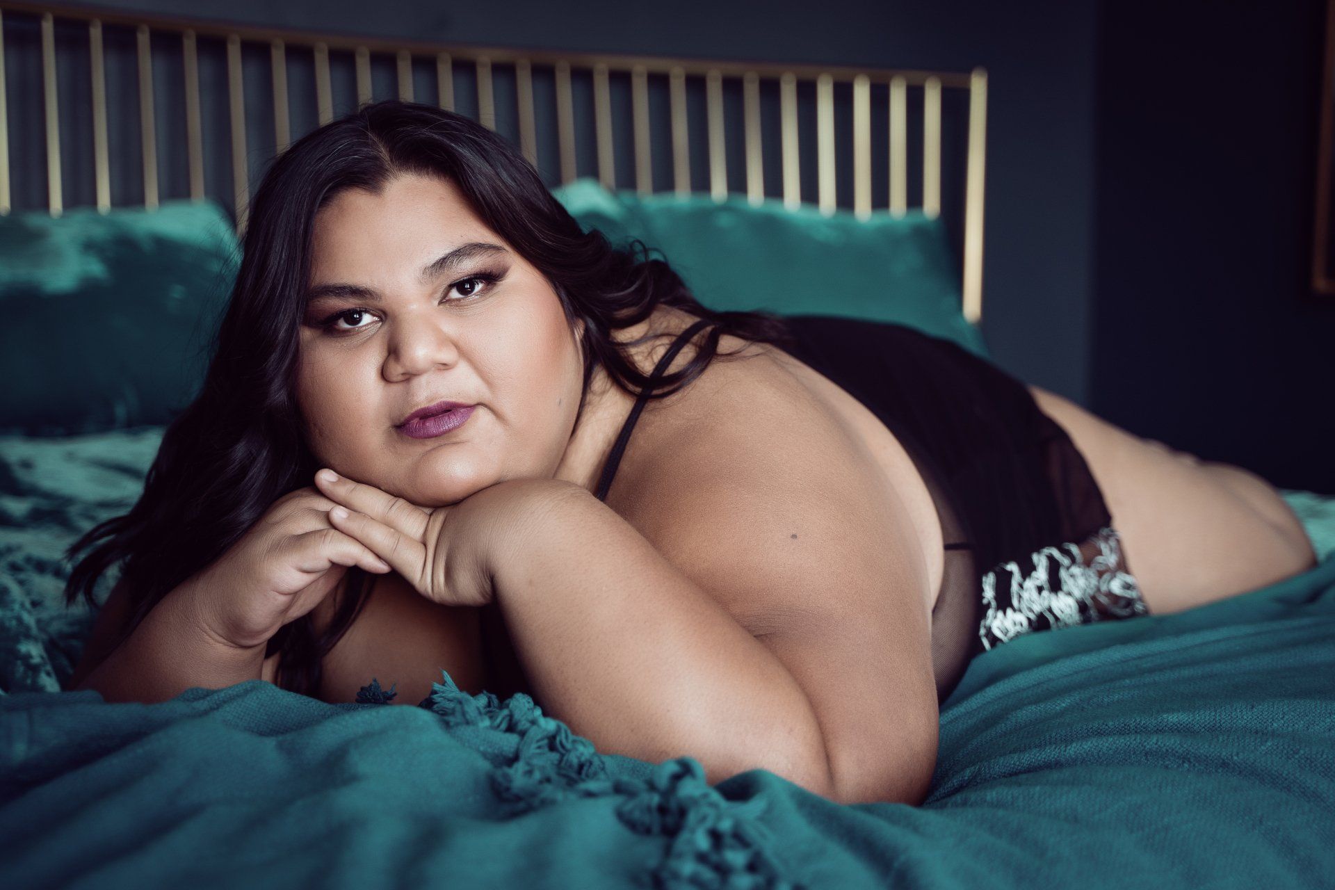 girl lying in bed in a green bedsheet